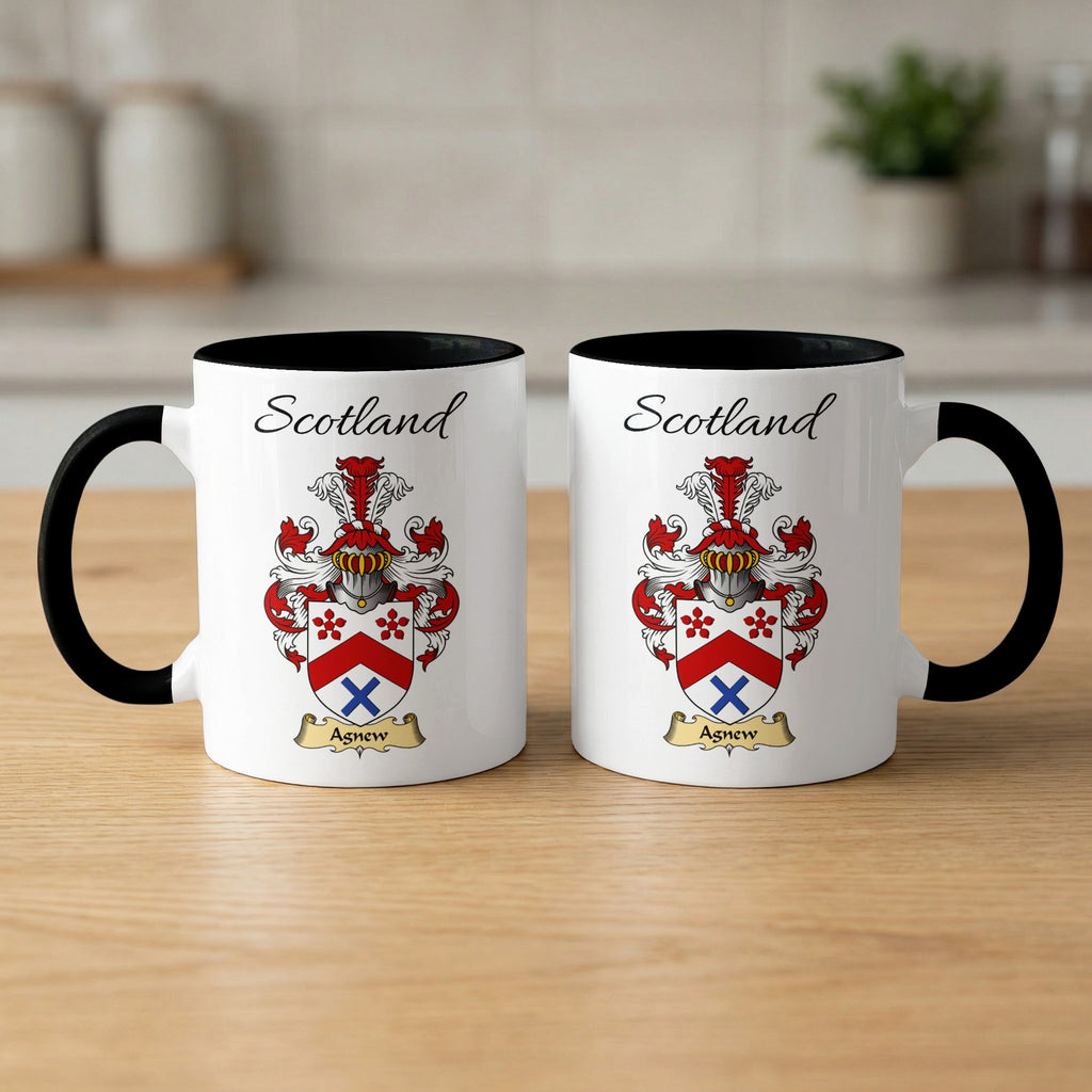 Pair of black-accent Agnew mugs showing the double-sided Scottish family shield design on white ceramic.