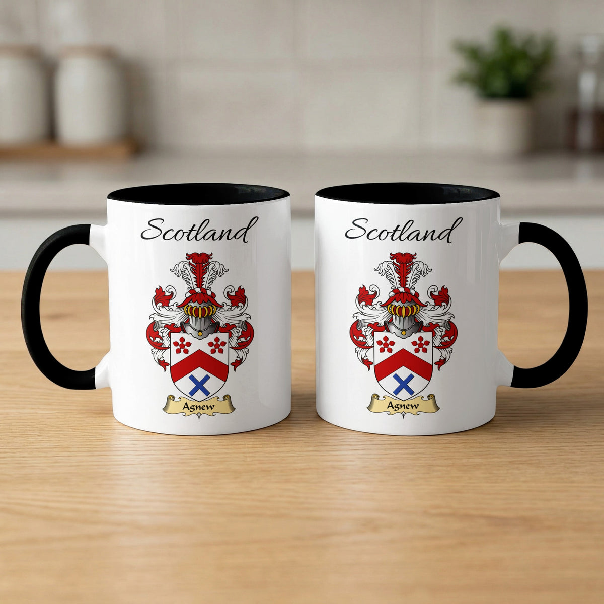 Pair of black-accent Agnew mugs showing the double-sided Scottish family shield design on white ceramic.