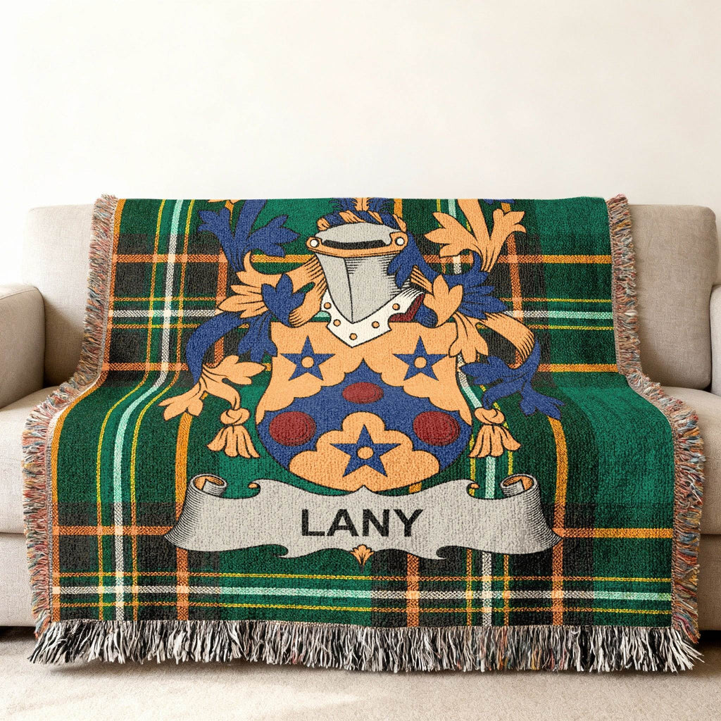 Green plaid throw blanket featuring the LANY family crest on a sofa.