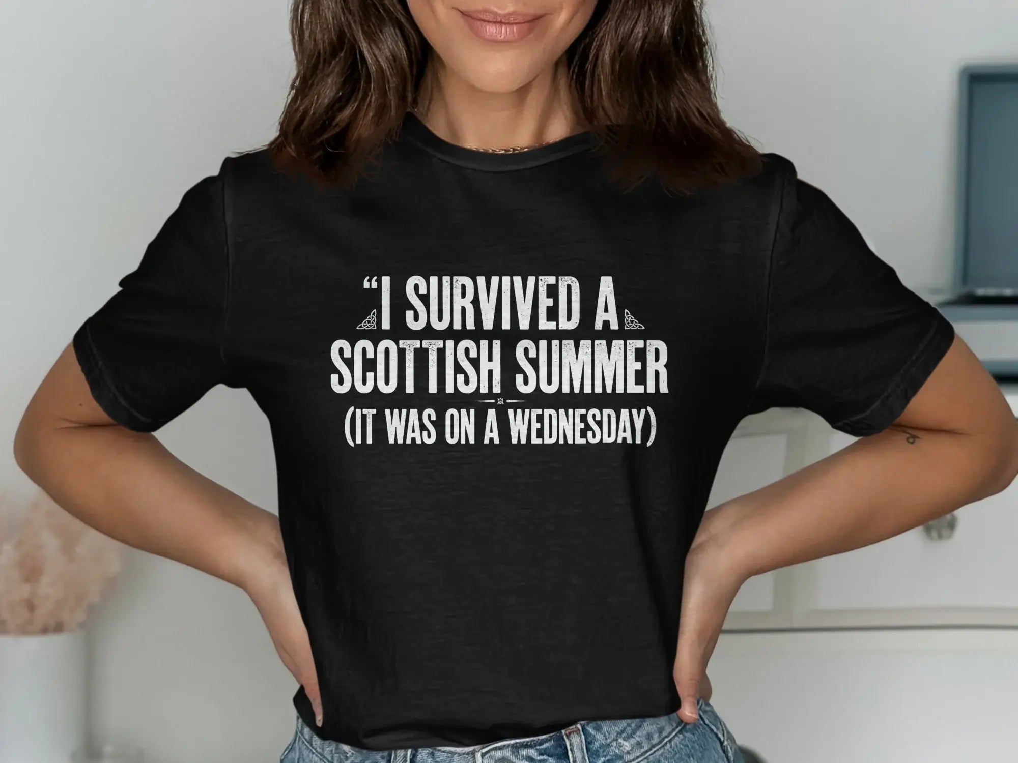 Black t-shirt with "I survived a Scottish summer (it was on a Wednesday)" text.