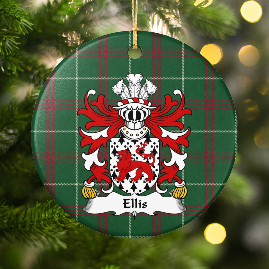 Ellis ornament hanging among Christmas tree branches and warm lights; a red walking lion on a white shield patterned with black ermine marks on Welsh national tartan.