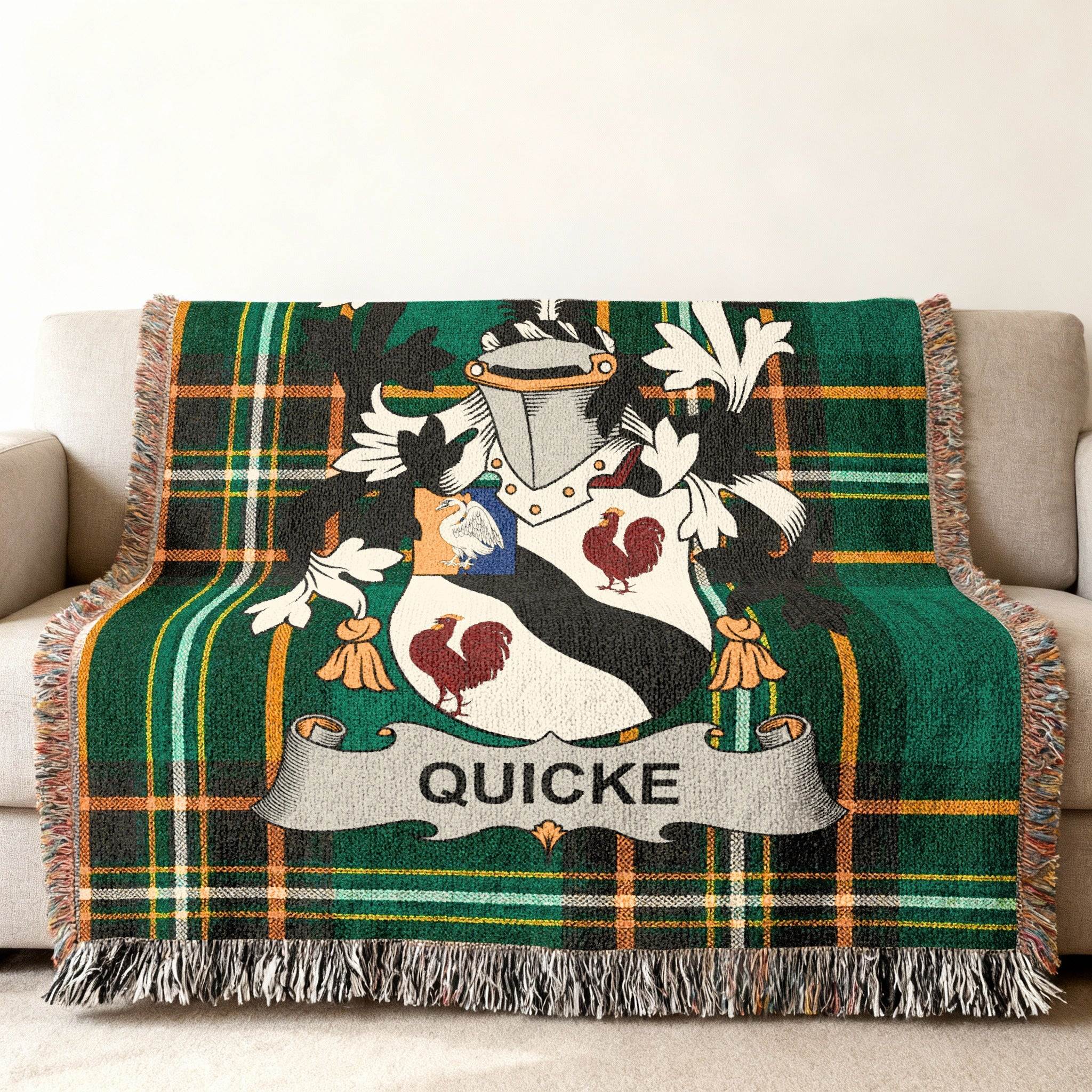Green tartan throw blanket with a coat of arms and the name QUICKE.