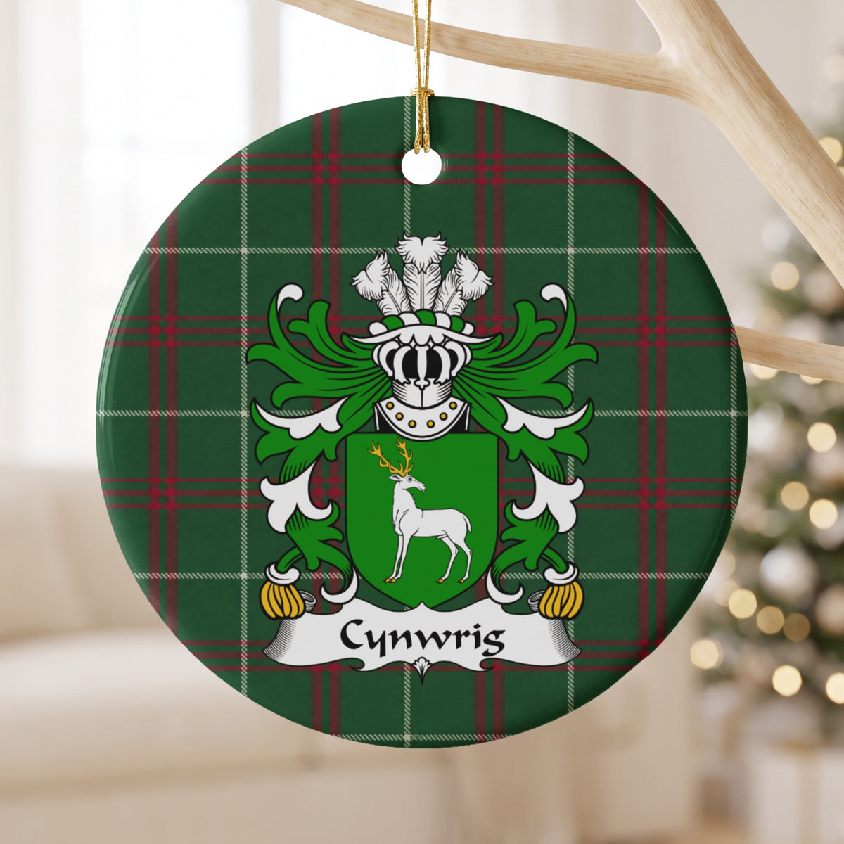 Cynwrig Style 2 ornament hanging from a pale wooden branch; a white stag with gold antlers on a green shield on Welsh national tartan.