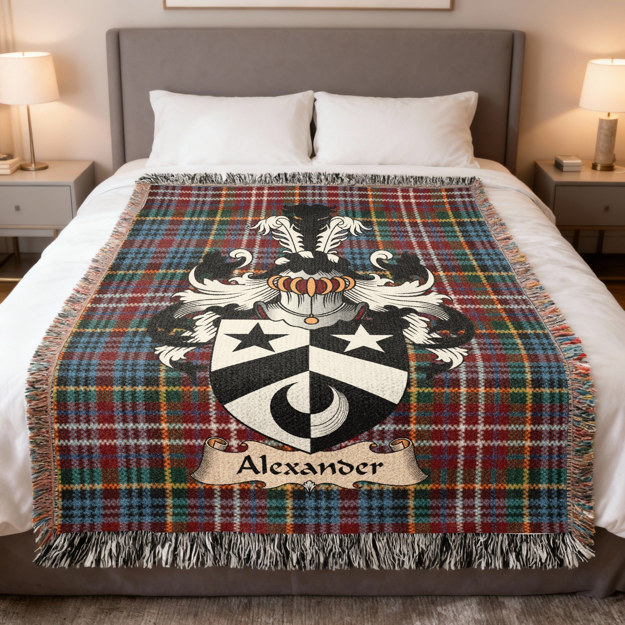 Alexander Scottish family crest woven blanket on a Caledonia tartan background, displayed on a bed