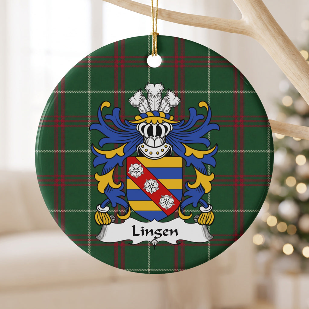 Lingen ceramic ornament hanging from a pale wooden branch, showing a blue-and-gold striped shield with three white roses on a red diagonal band on Welsh national tartan.