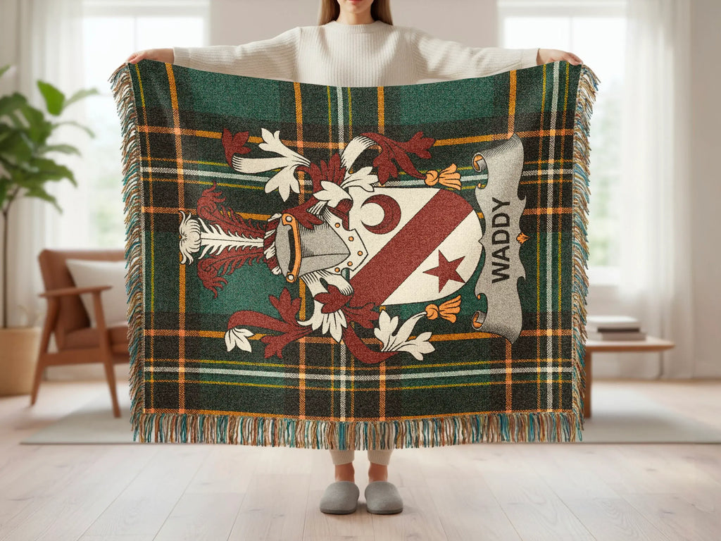 Tartan throw blanket with a family crest featuring a crescent moon and shield.