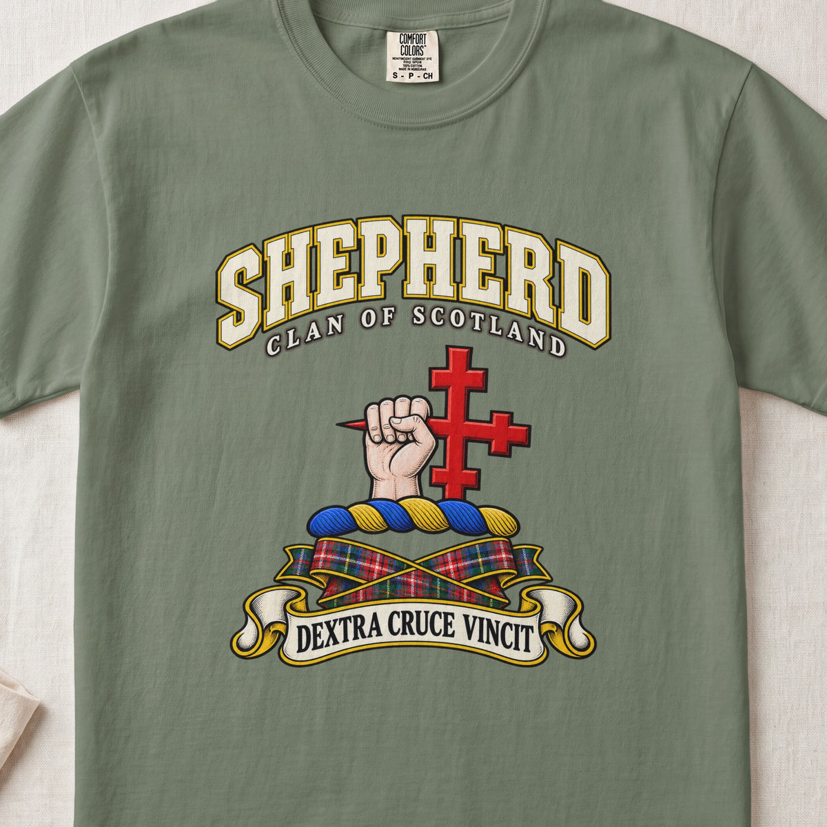 Shepherd Scottish clan T-shirt in Moss, front view with a hand holding a red cross and motto banner.