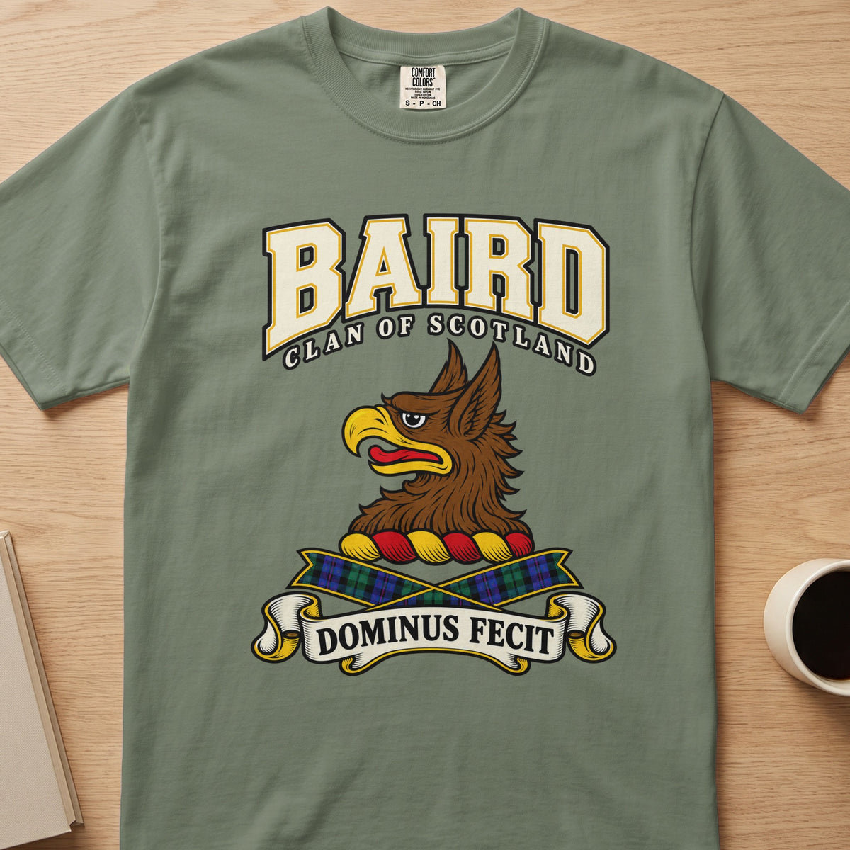Baird clan crest with brown griffin head on a sage green Comfort Colors T-shirt, front view
