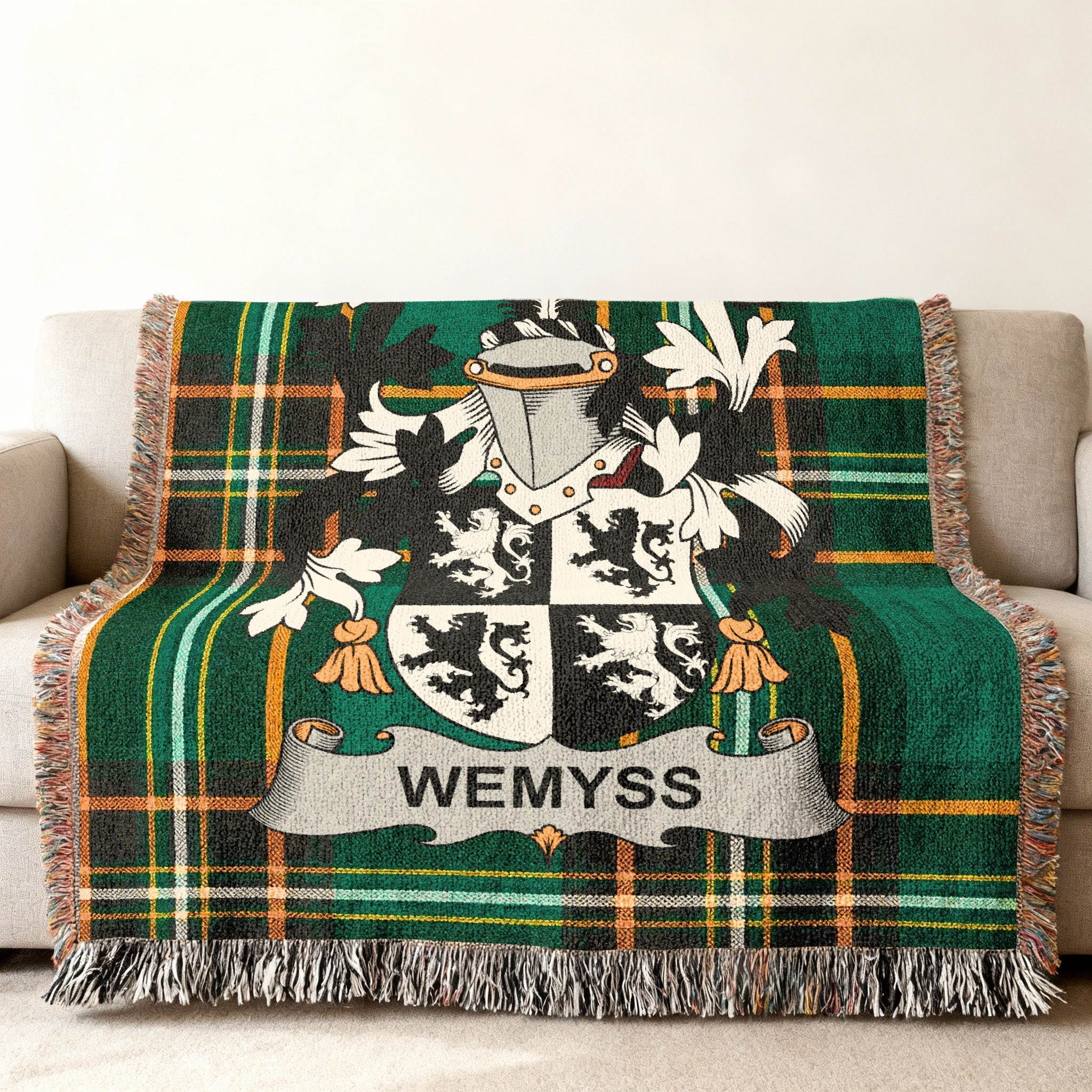 Wemyss tartan throw blanket with family crest on a sofa.