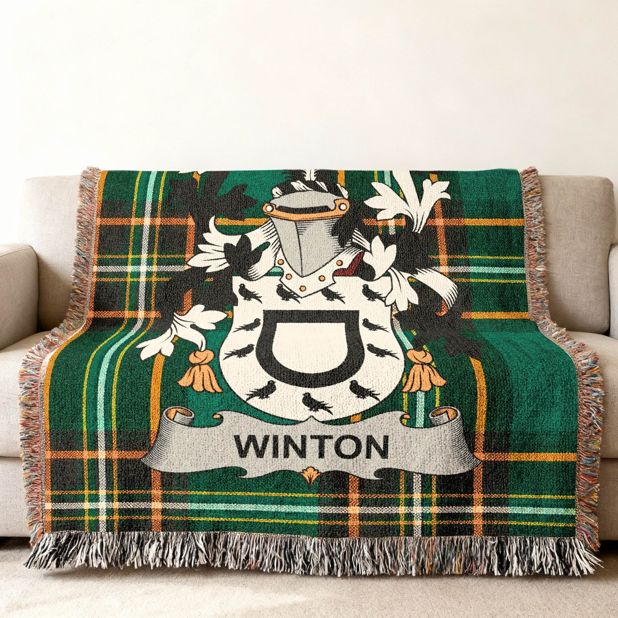 Winton family crest on a green plaid throw blanket with fringe.