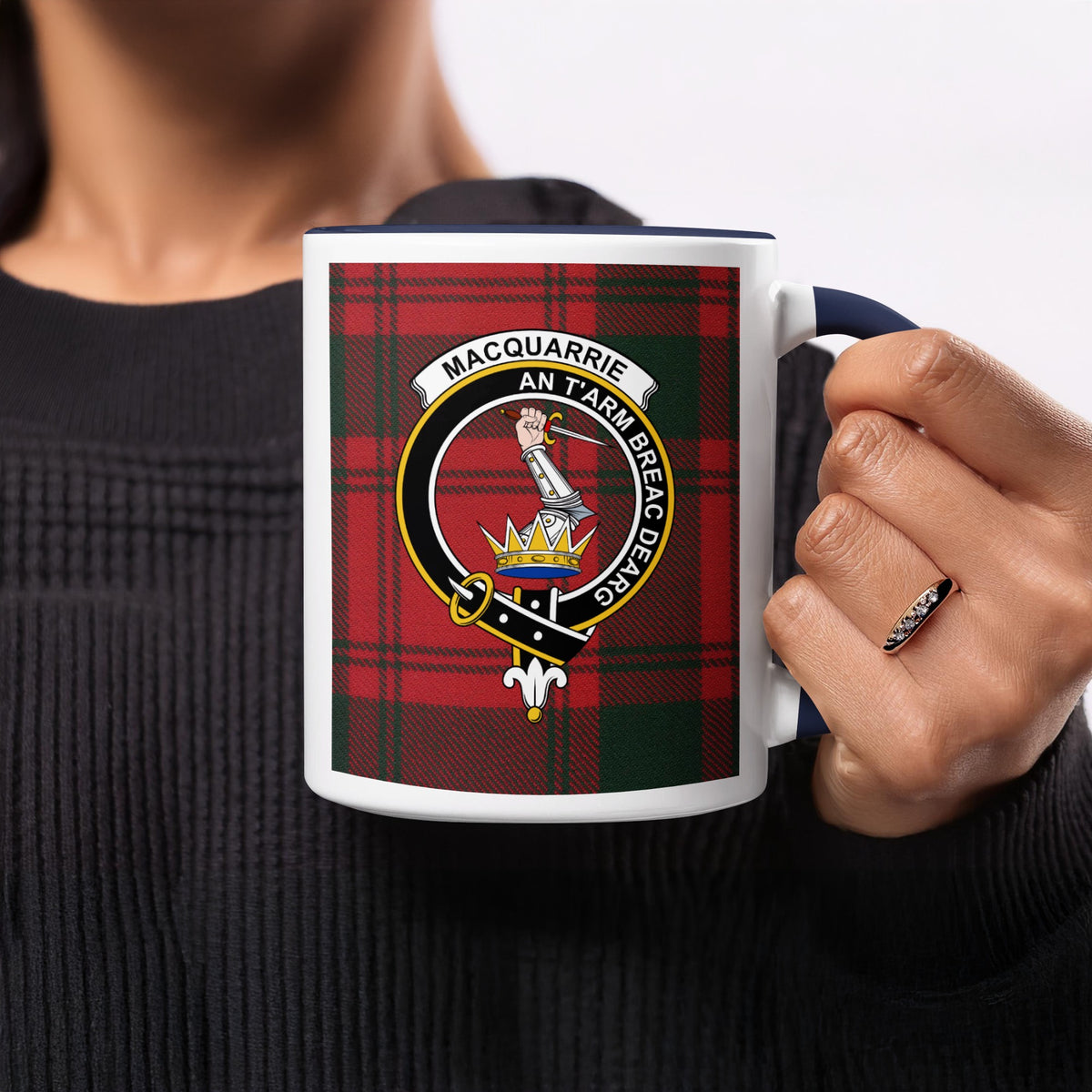 Close-up lifestyle view of MacQuarrie Scottish clan crest artwork on a navy 11 oz accent mug with a tartan background