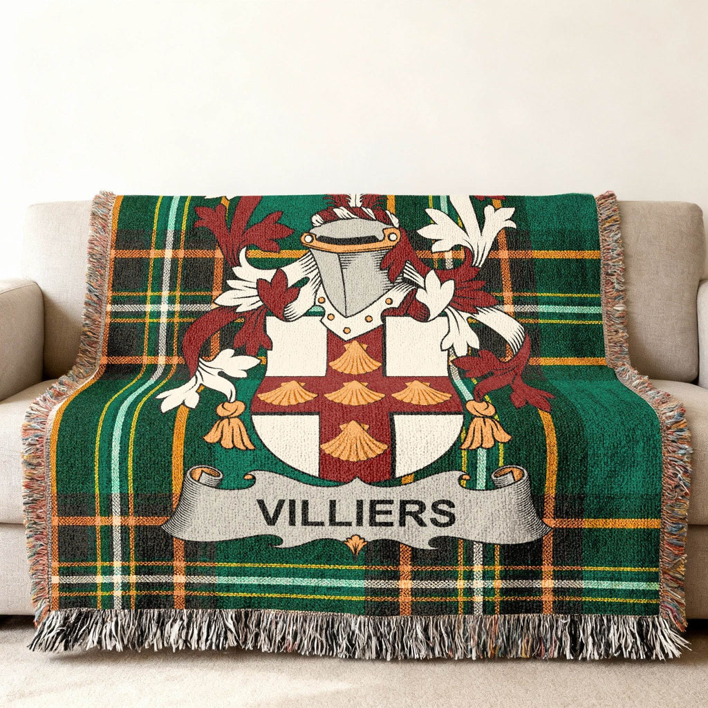 Green plaid blanket featuring the Villiers family crest on a couch.