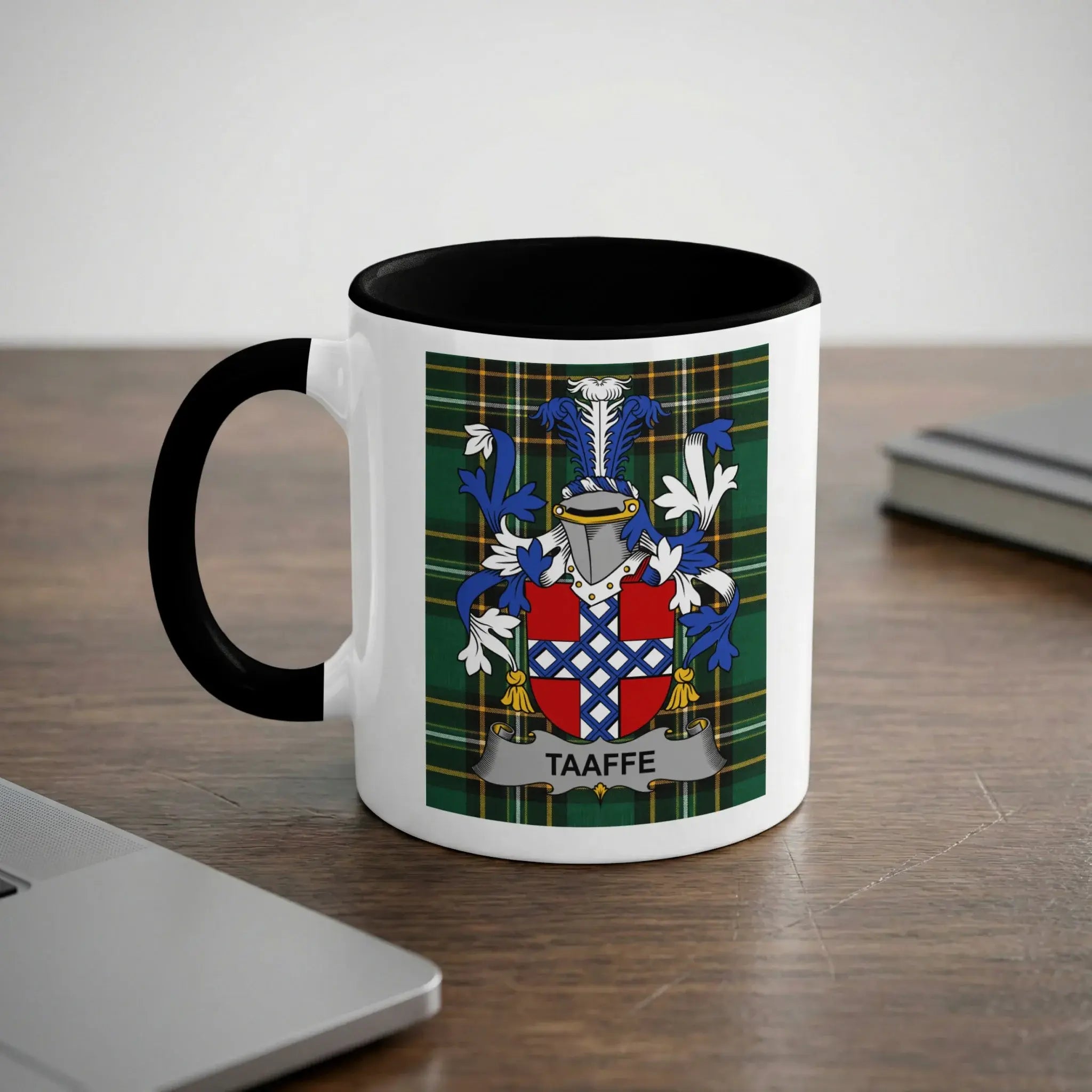 White mug with black rim and handle, displaying a family crest with the name TAAFFE.