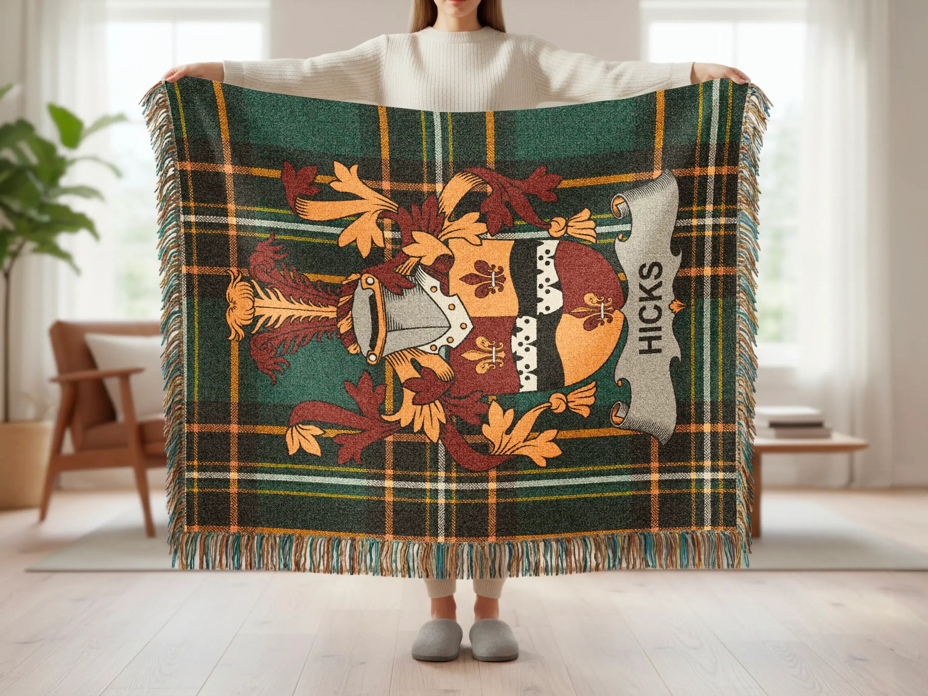 Tartan throw with a family crest and "Hicks" text, held by a person.