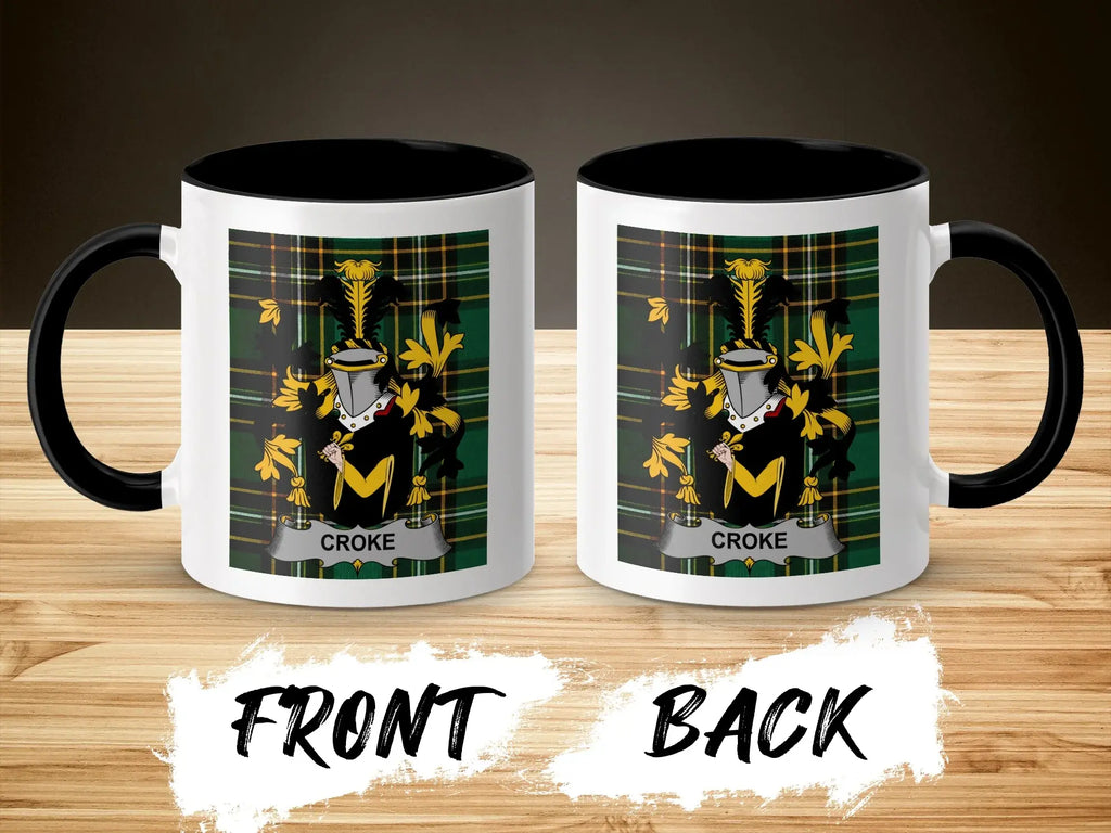 Two mugs with the Croke family crest on a wooden background.