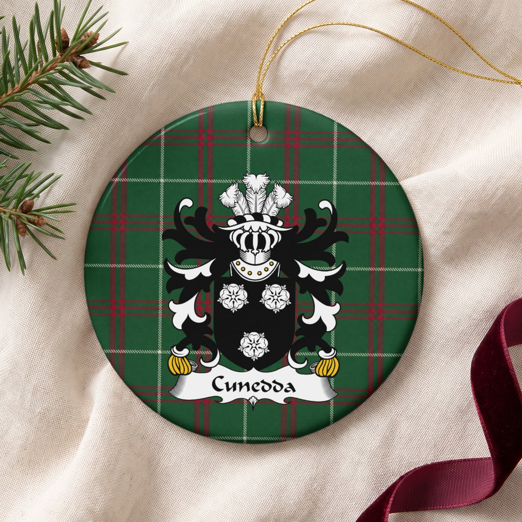 Cunedda ornament on cream fabric with gold string, evergreen and burgundy ribbon; three white rose motifs on a black shield.
