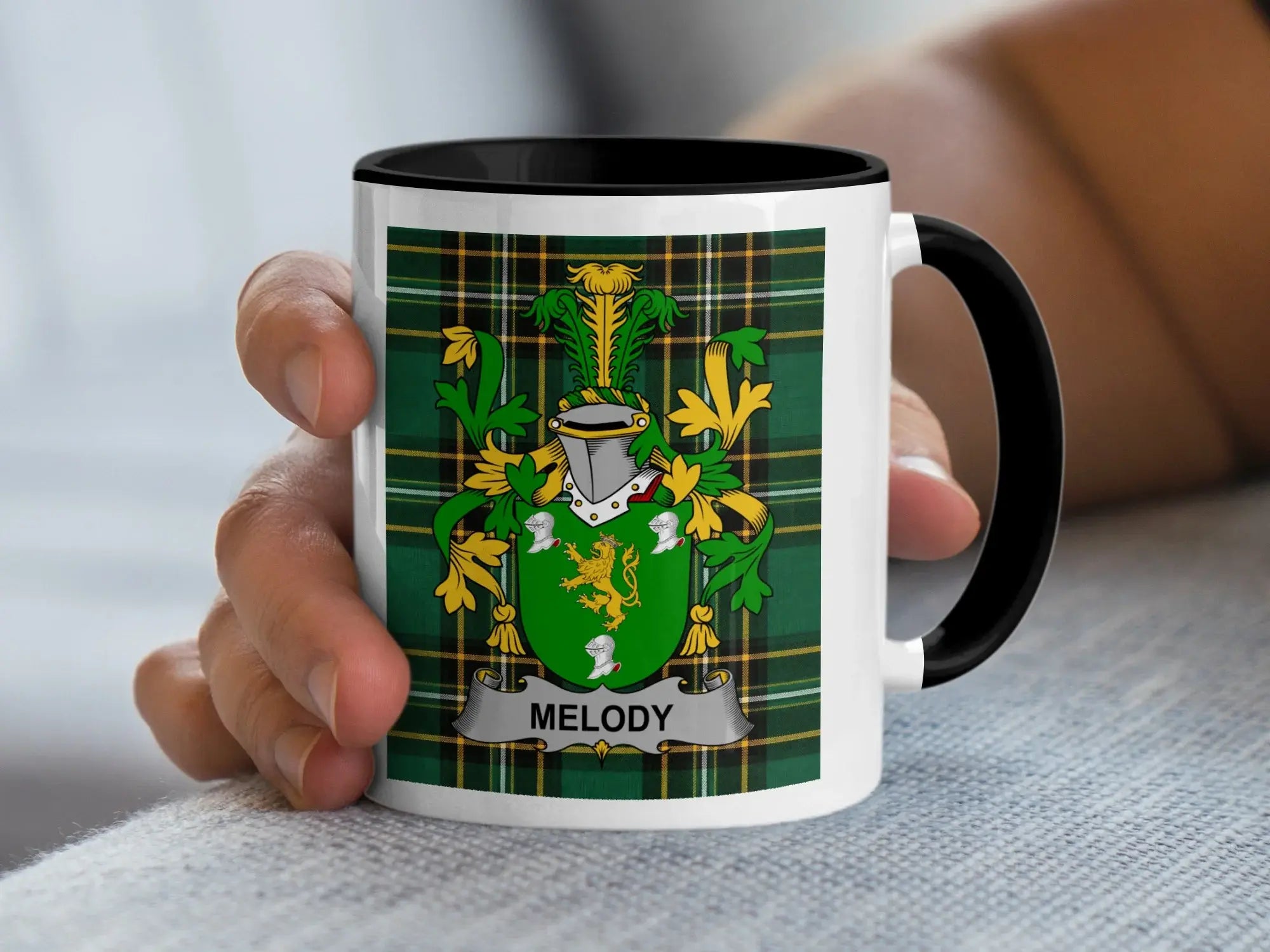 White mug with black rim featuring a green tartan background and a heraldic crest with the name "Melody".