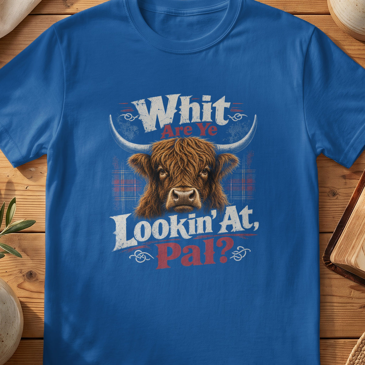 Blue t-shirt with Highland cow graphic and text "Whit Are Ye Lookin' At, Pal?".