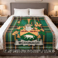 McDonagh tartan crest blanket with fringe, draped on a bed.