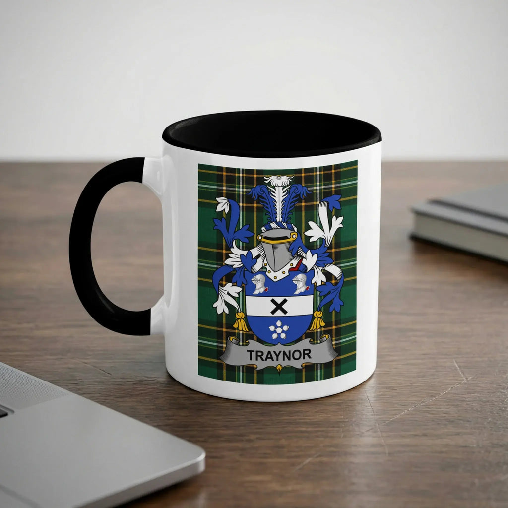 White mug with black handle featuring the Traynor family crest on a plaid background.