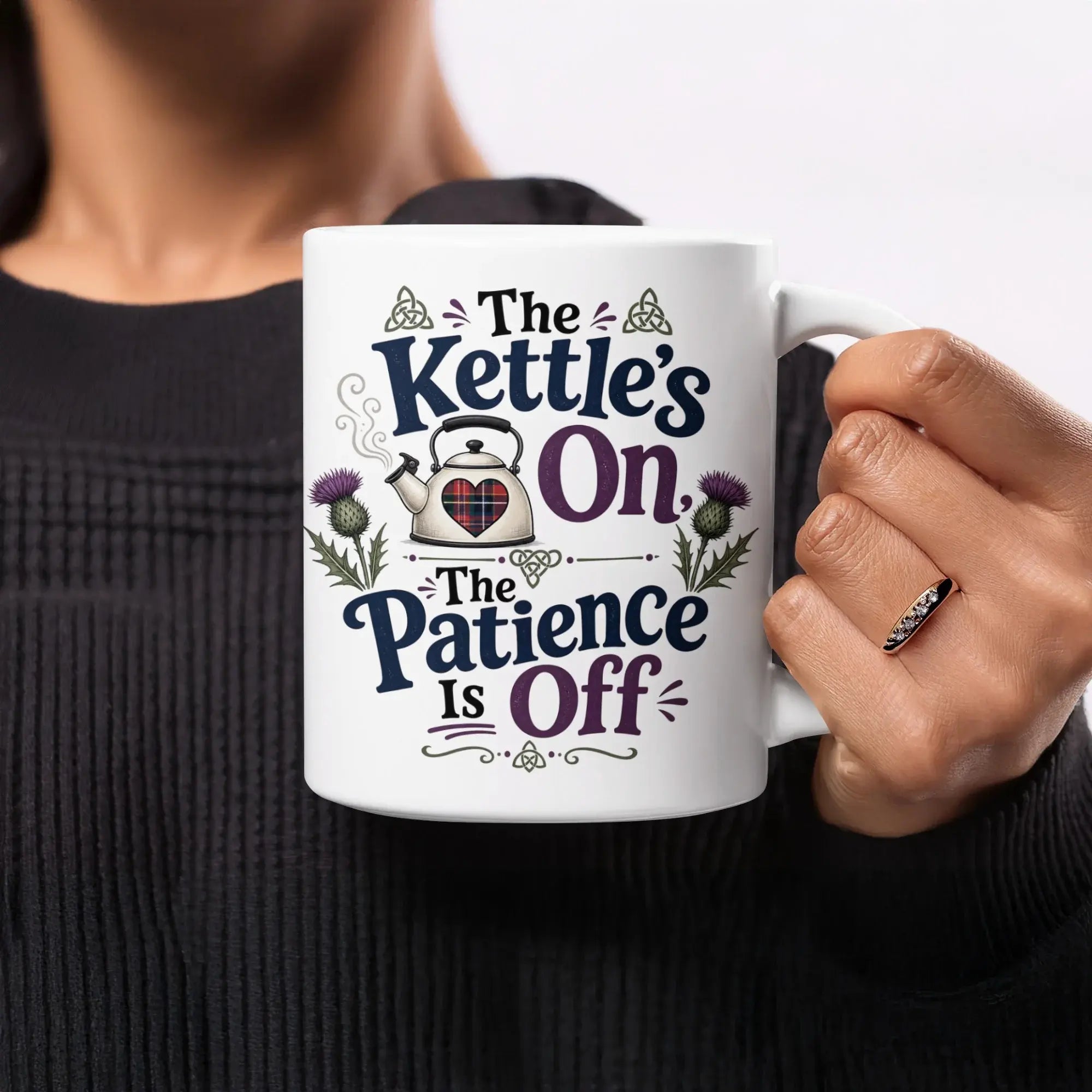 White mug with "The Kettle's On, The Patience Is Off" text and thistle designs.