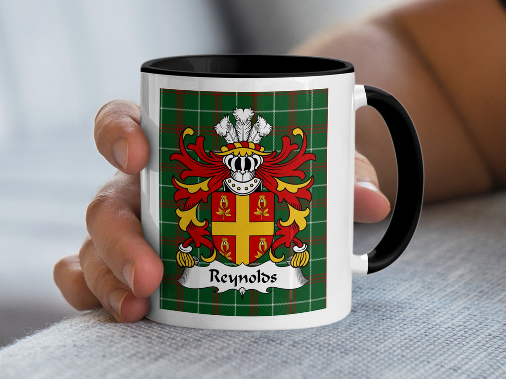 White mug with black handle featuring a green plaid background and the Reynolds coat of arms.