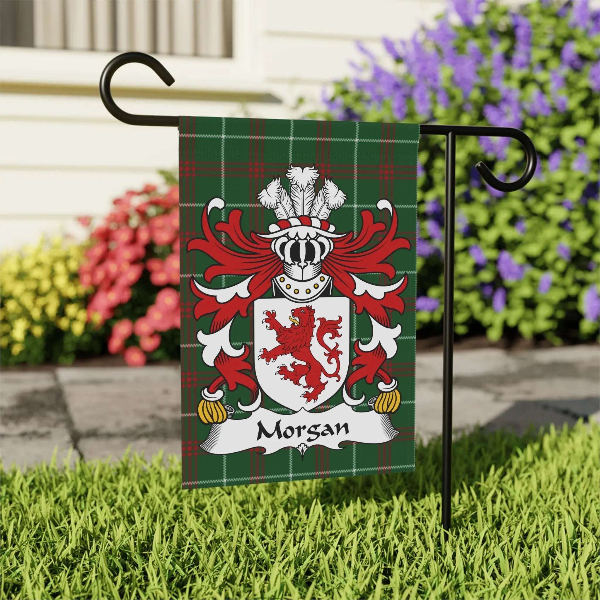 Morgan family crest on a plaid garden flag, displayed outdoors.