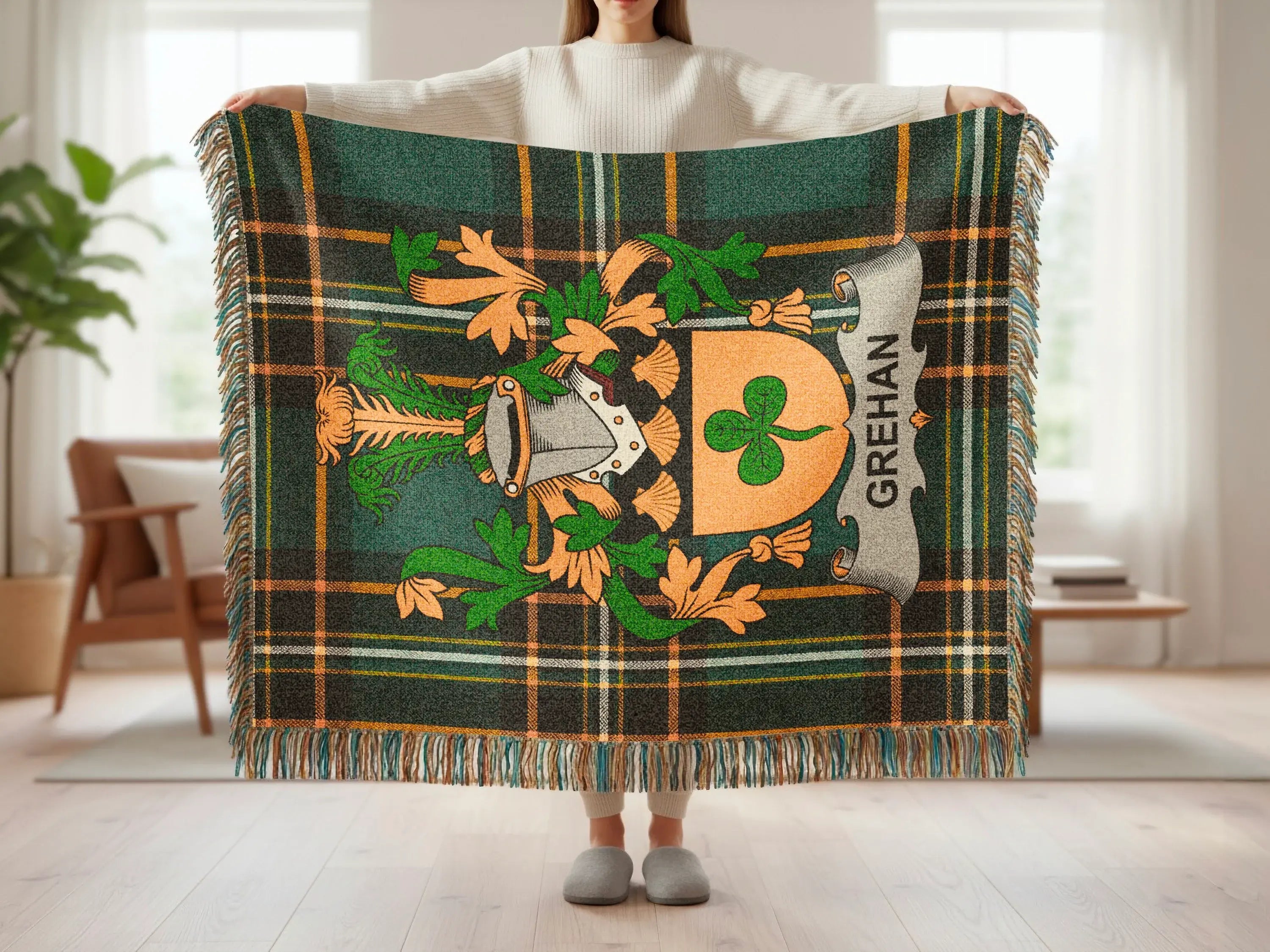 Green and orange plaid blanket with a family crest, held by a person.