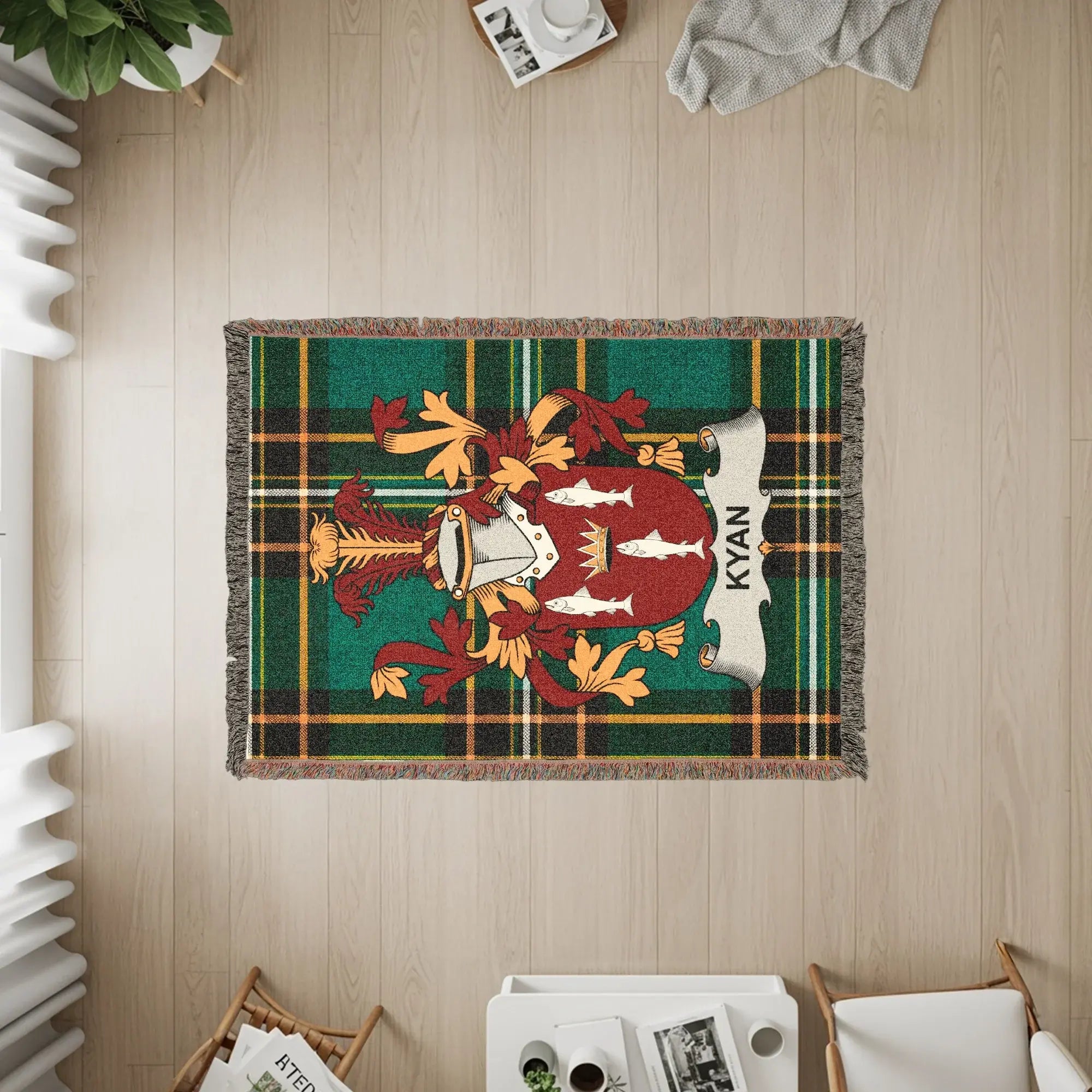 Green plaid throw blanket featuring a family crest with shield and fish.
