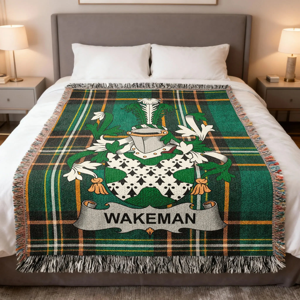Wakeman family crest on a green tartan plaid blanket draped on a bed.