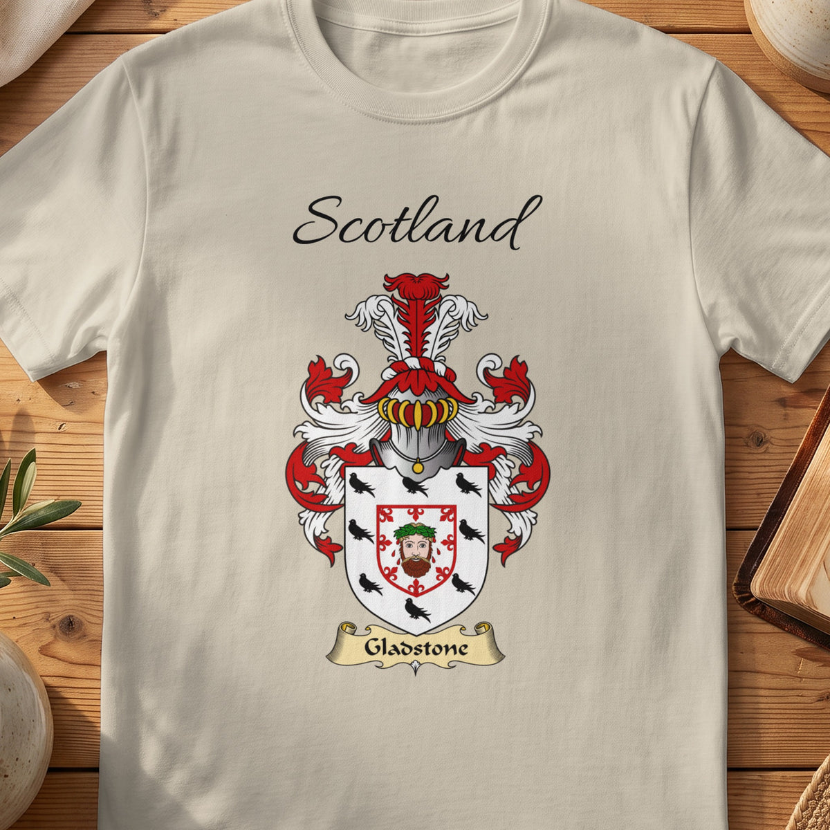 Sand Gladstone Scottish family shield T-shirt featuring a central face motif framed by a red border