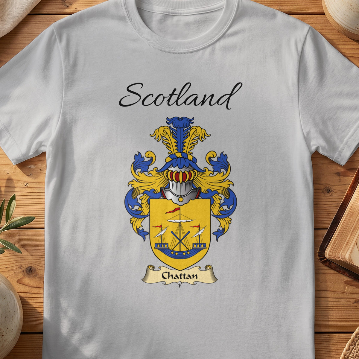 White t-shirt with "Scotland" text above a coat of arms with "Chattan" banner.