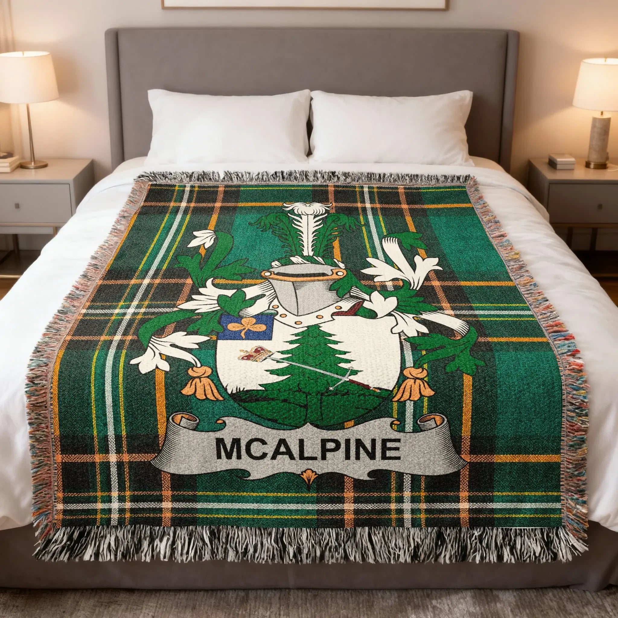 McAlpine tartan blanket with coat of arms centered on a bed.