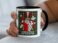 White mug with black handle featuring the Blanchfield coat of arms on a green plaid background.