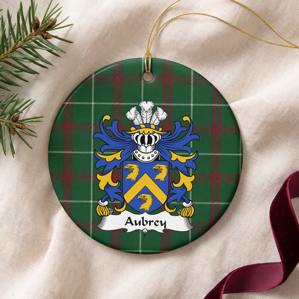 Aubrey ceramic ornament with gold string on cream fabric; three gold eagle heads and a gold chevron on a blue shield on Welsh national tartan.