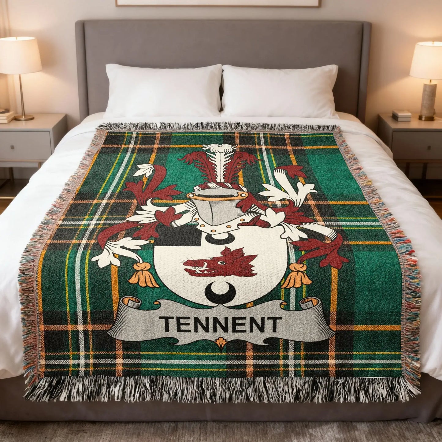 Tartan blanket with Tennent coat of arms centered on a bed.