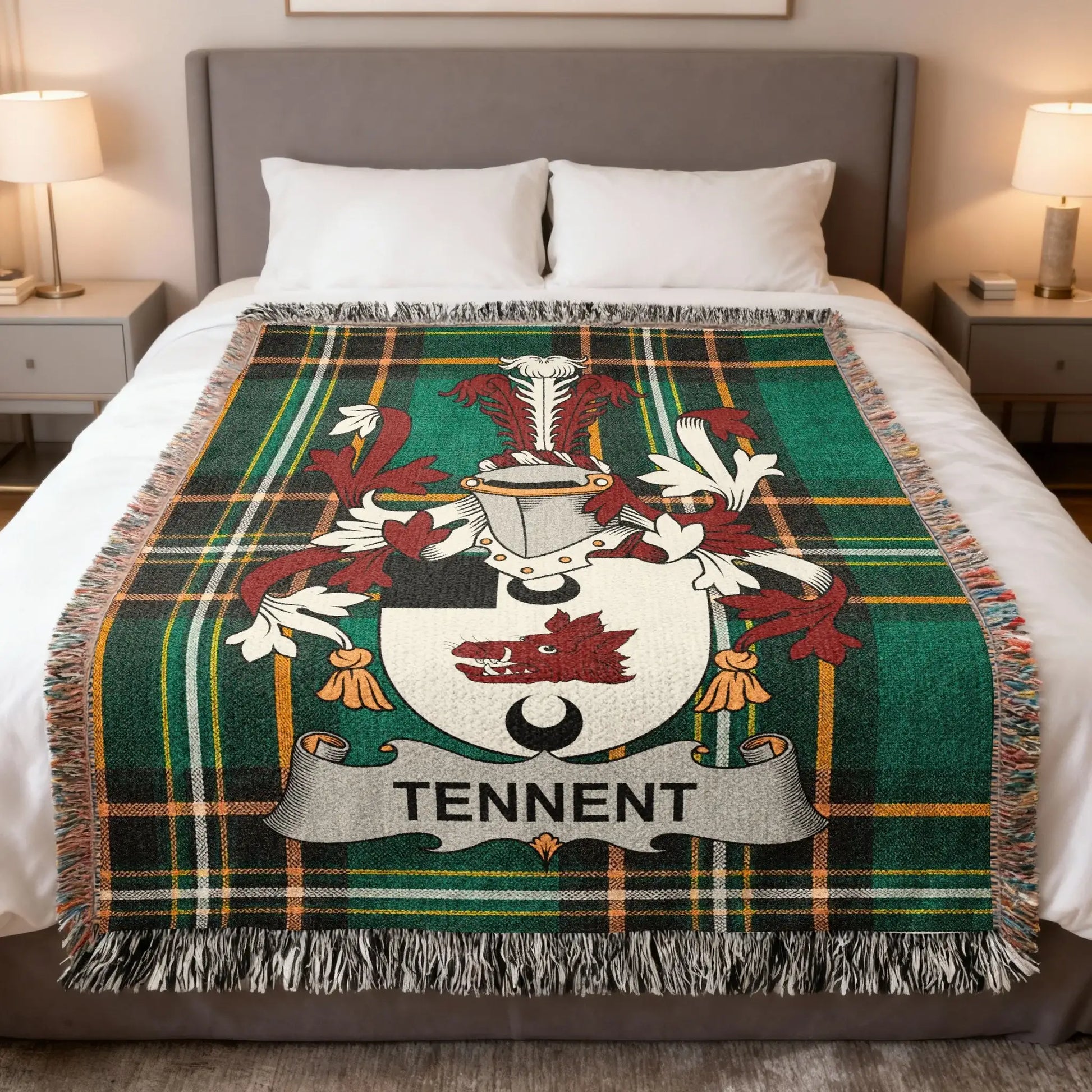 Tartan blanket with Tennent coat of arms centered on a bed.