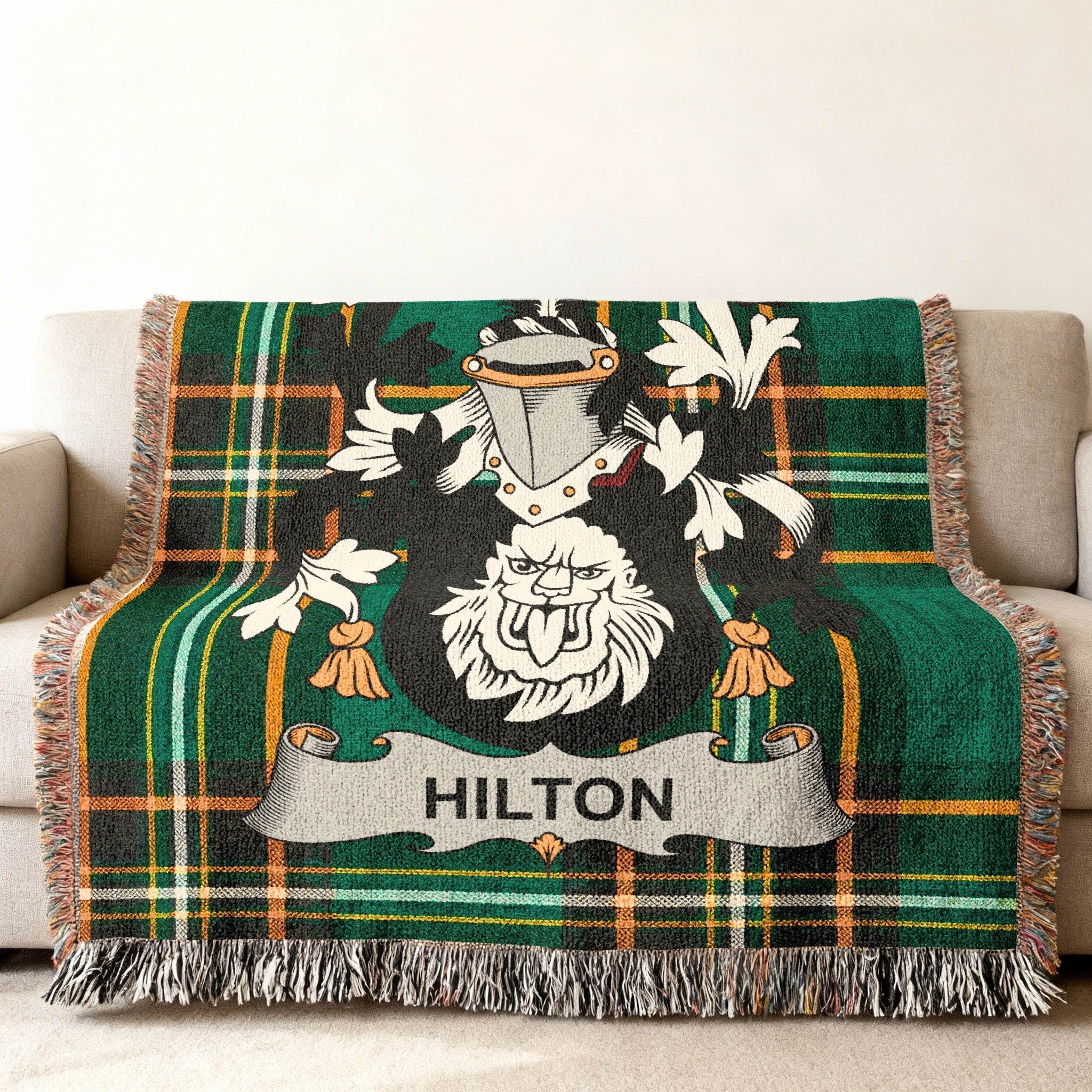 Green plaid blanket with a lion crest and the name "HILTON" in the center.