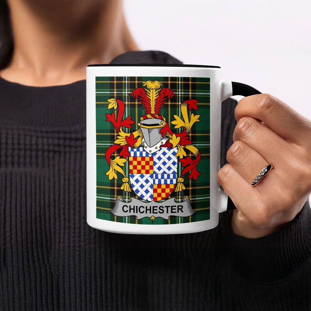 White mug with black handle displaying the Chichester family crest on a green plaid background.