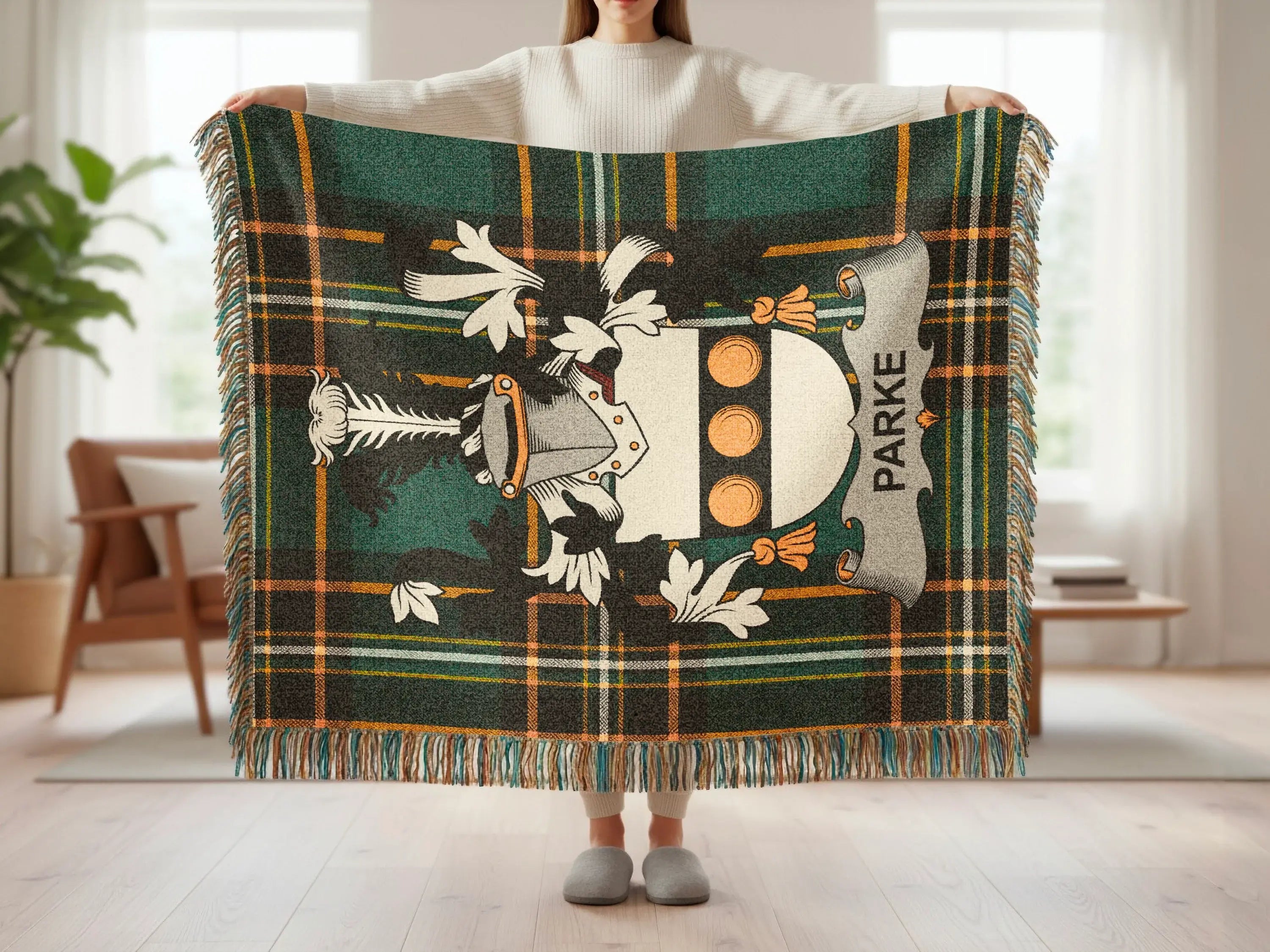 Tartan blanket with crest and "PARKE" text held by a person.