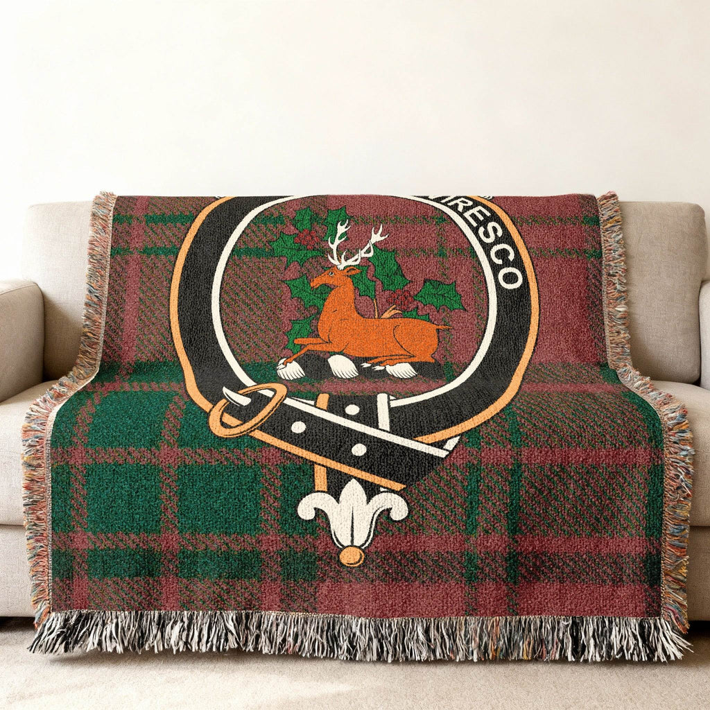 Maxwell Reviresco stag crest tartan woven blanket draped over sofa — clan colours in cotton