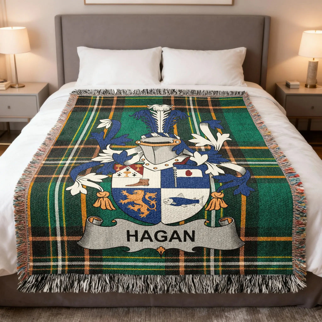 Tartan blanket with Hagan family crest displayed on a bed.