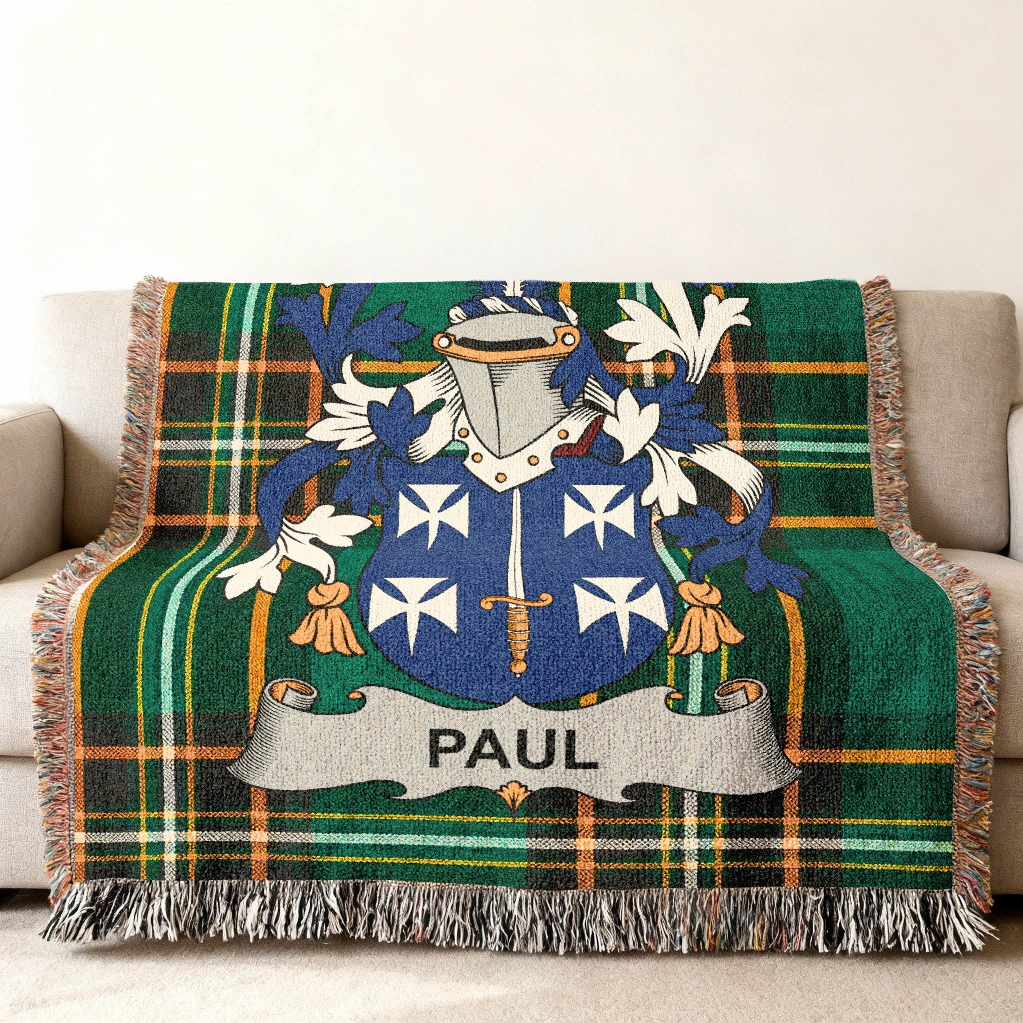 Plaid throw blanket with Paul family crest, featuring blue and white shield.