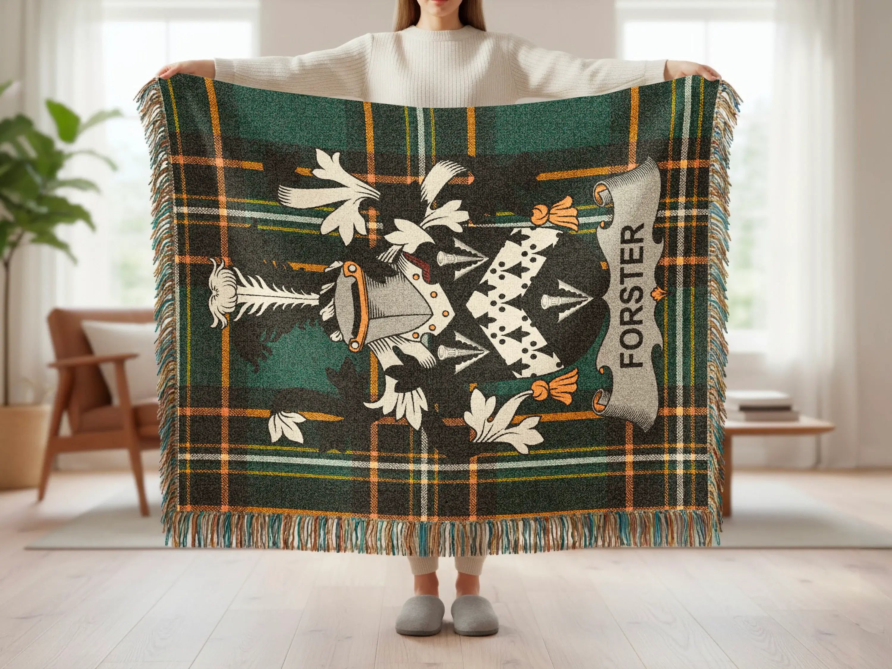 Tartan blanket with Forster crest held up by person.