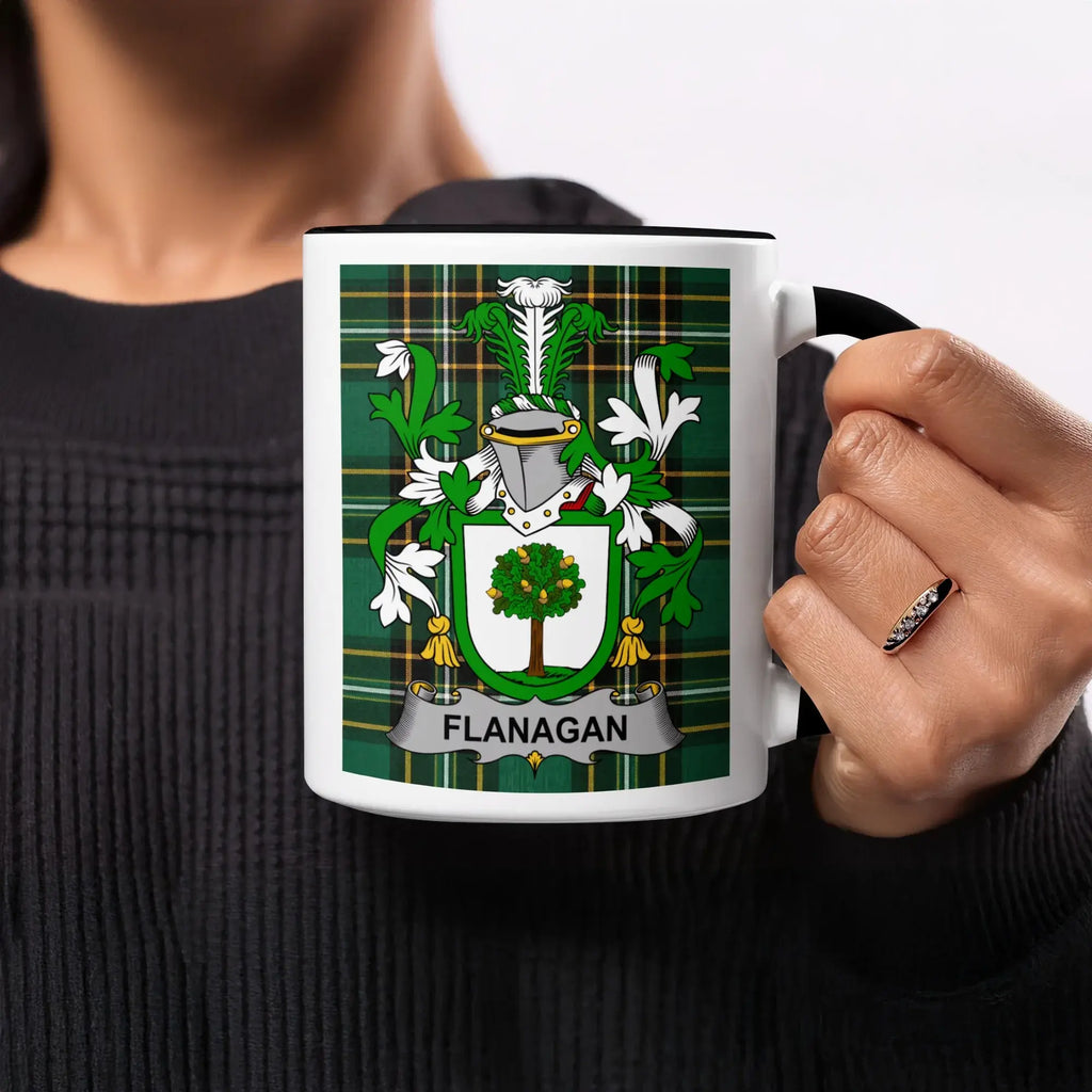 White mug with black handle displaying the Flanagan family crest on a green plaid background.