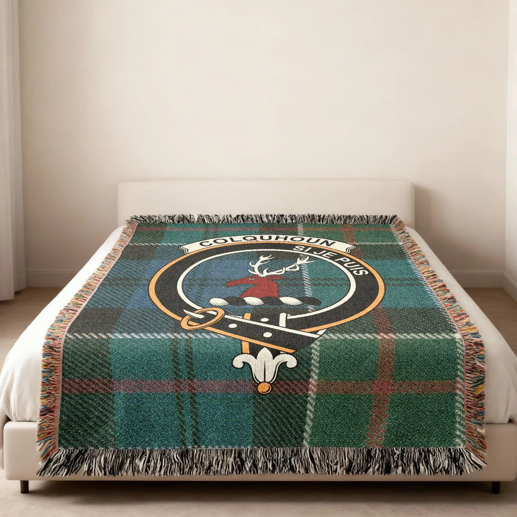 Colquhoun shield emblem tartan woven blanket — clan crest at centre, fringe edge visible