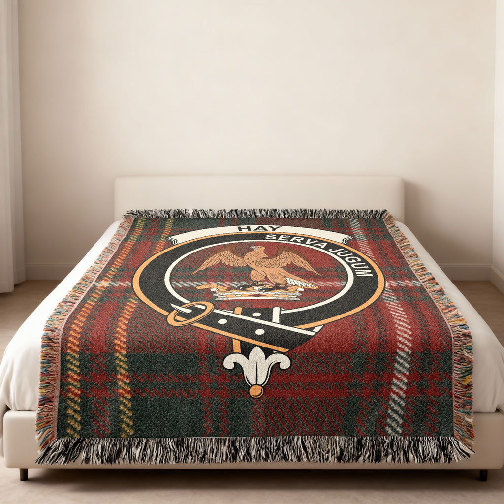 Hay family crest with falcon and Serva Jugum motto woven into tartan blanket