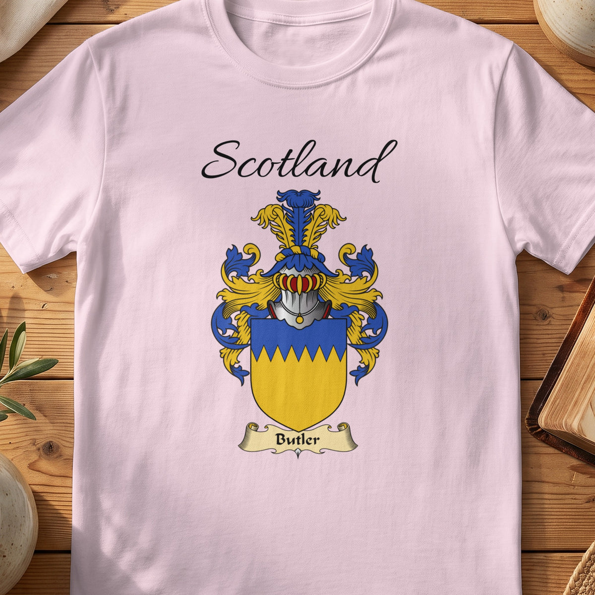 Light Pink Butler Scottish family shield T-shirt featuring a gold shield beneath a blue zigzag top band
