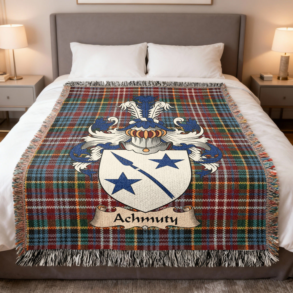Achmuty Scottish family crest woven blanket on a Caledonia tartan background, displayed on a bed