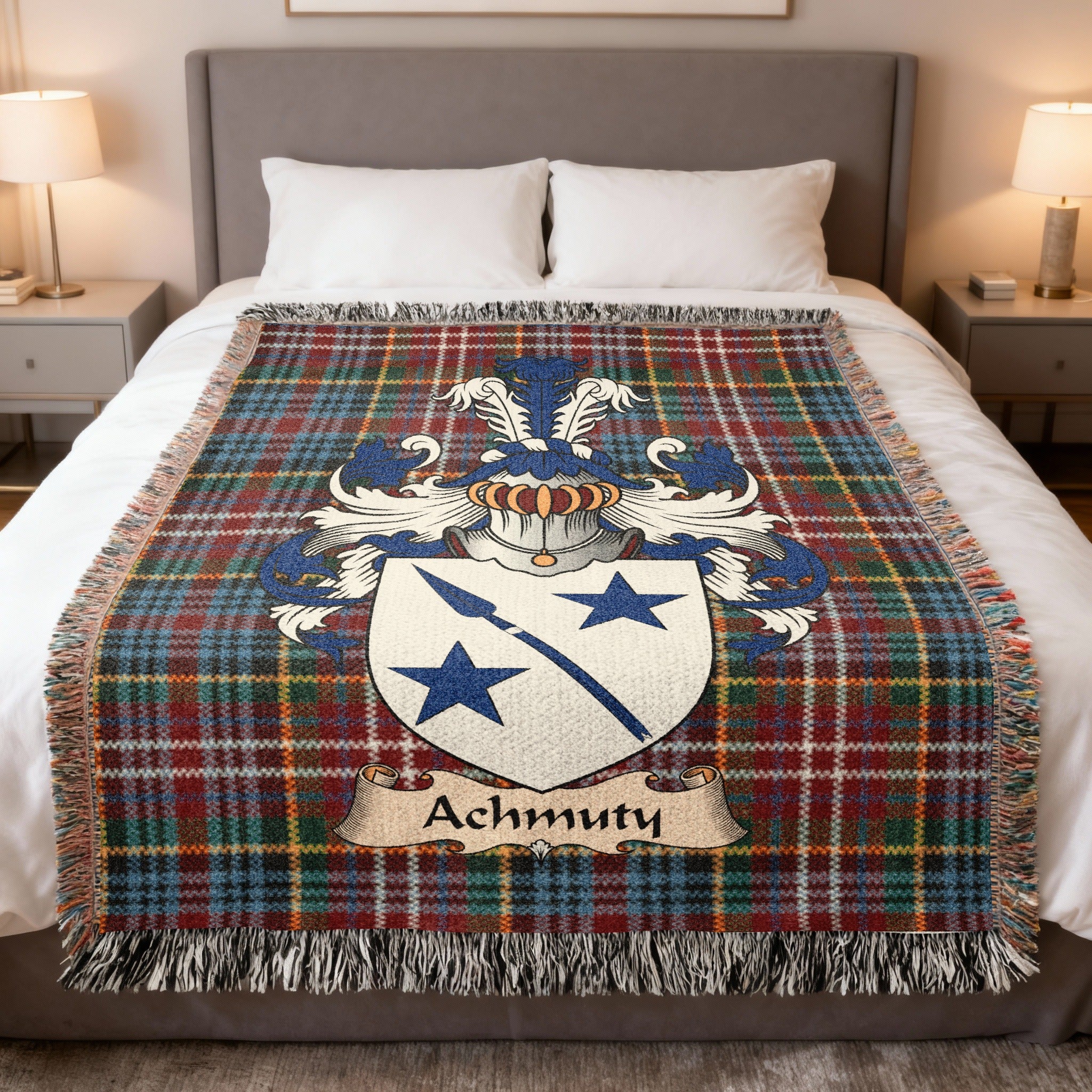 Achmuty Scottish family crest woven blanket on a Caledonia tartan background, displayed on a bed